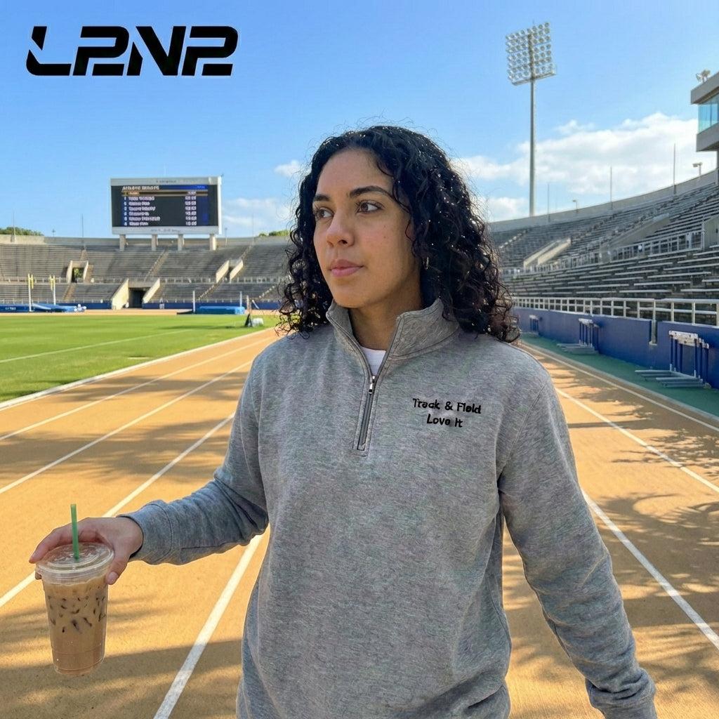 Carbon Grey fleece pullover with soft interior, relaxed fit, and ribbed cuffs for track and field warmth