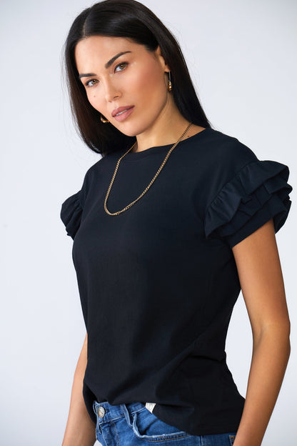 Woman wearing Ella Ruffle Sleeve Tee with double ruffle short sleeves and relaxed fit paired with blue jeans